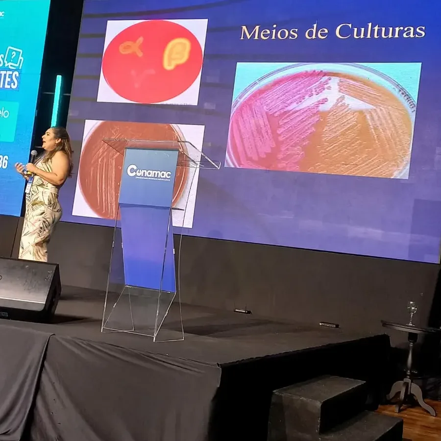 Dra. Cristiane palestrando no palco do CONAMAC sobre meios de cultura